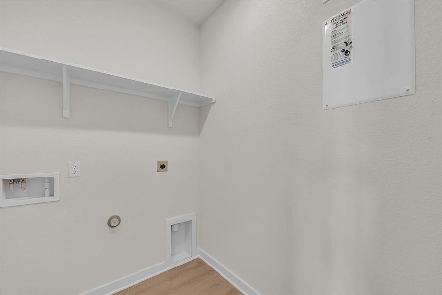 Laundry room with hookup for a gas dryer, light wood finished floors, hookup for a washing machine, and hookup for an electric dryer