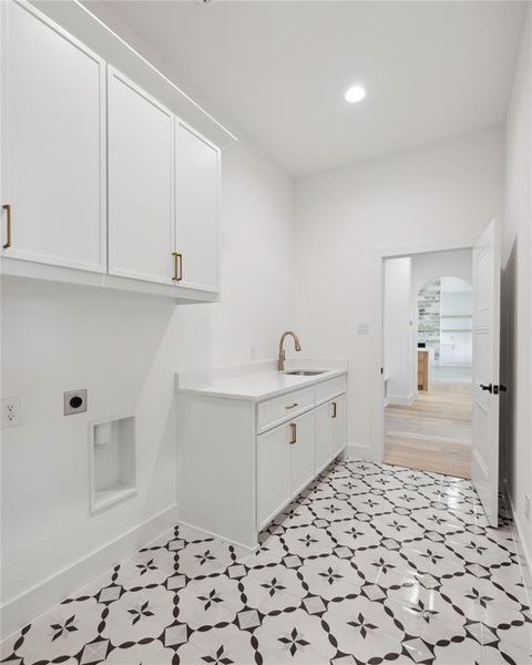 Clothes washing area with hookup for an electric dryer, cabinets, and sink