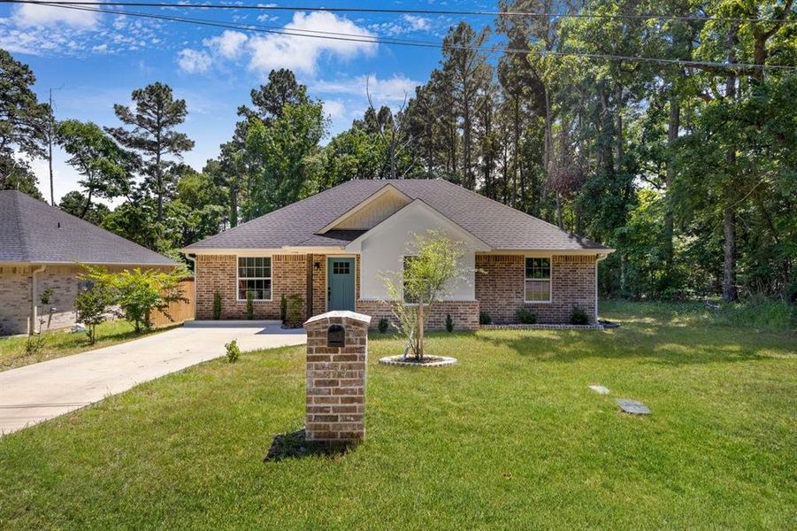 Ranch-style house with brick siding, driveway, and a front yard Ranch-style house with brick siding, driveway, and a front yard