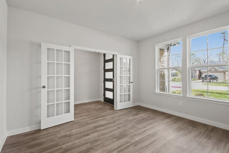 A room with a wood floor and white walls.