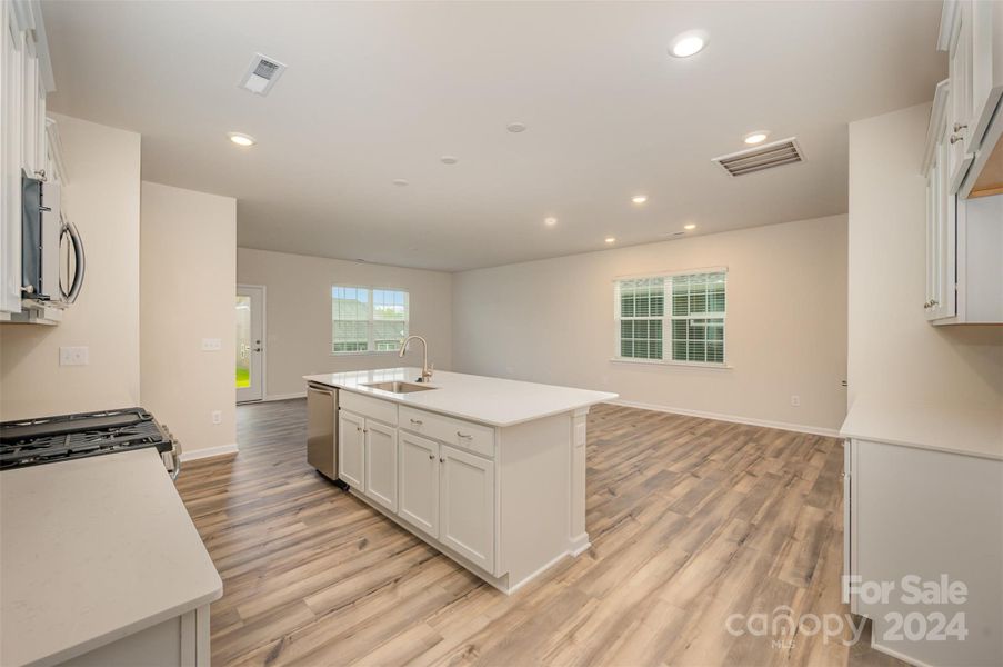 Open kitchen design with quartz counter tops and center island.