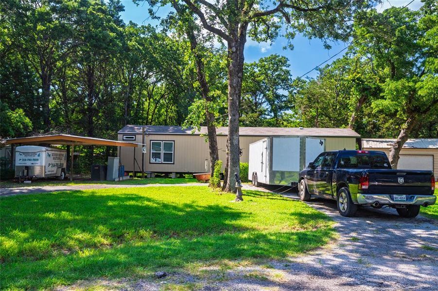 View of front of house with a front yard and a detached carport
