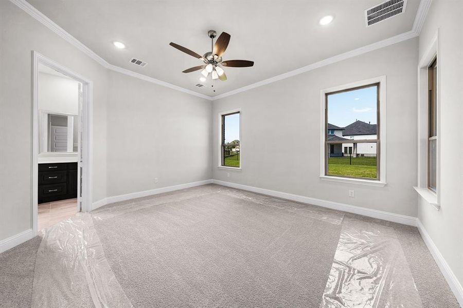 Unfurnished bedroom with light colored carpet, crown molding, recessed lighting, ensuite bath, and a ceiling fan Unfurnished bedroom with light colored carpet, crown molding, recessed lighting, ensuite bath, and a ceiling fan