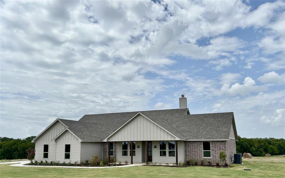 View of front of property featuring roof with shingles, board and batten siding, a front lawn, a chimney, and covered porch View of front of property featuring roof with shingles, board and batten siding, a front lawn, a chimney, and covered porch