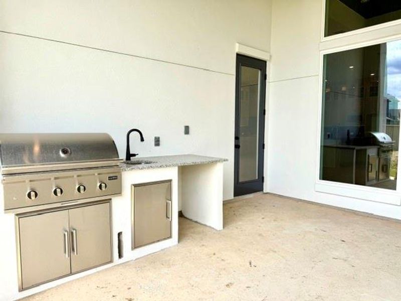An outdoor kitchen with a built-in grill and sink extends entertaining possibilities. An outdoor kitchen with a built-in grill and sink extends entertaining possibilities.