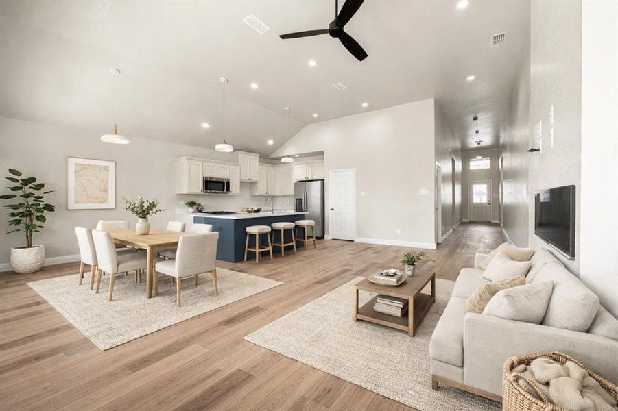 Living room featuring light wood finished floors, a ceiling fan, recessed lighting, and vaulted ceiling