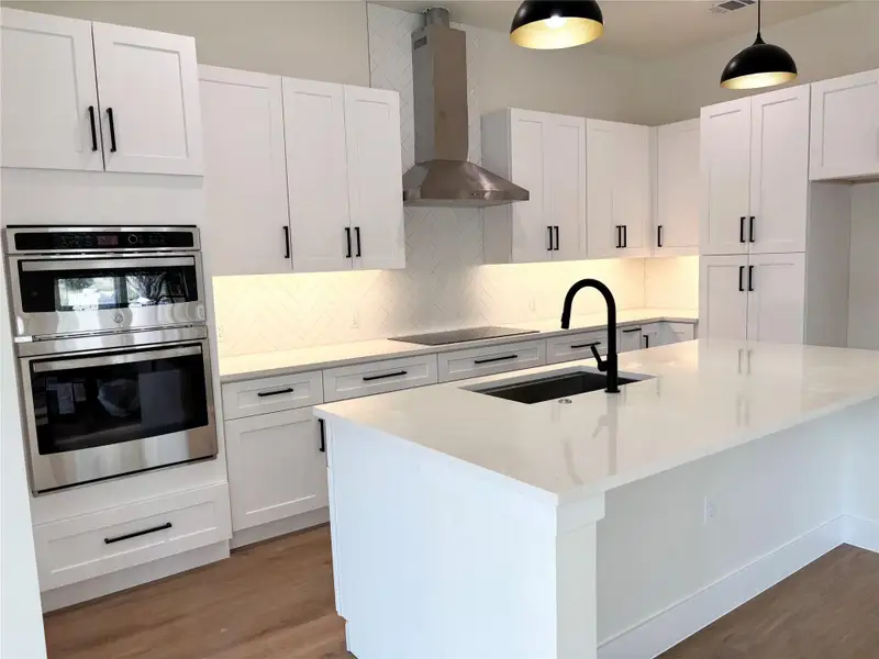 White cabinetry, quartz counters, and modern appliances outfit this luminous culinary space. White cabinetry, quartz counters, and modern appliances outfit this luminous culinary space.