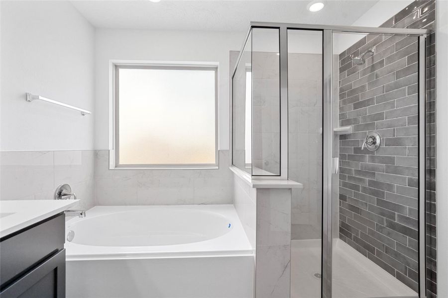 Additional view of the primary bathroom featuring a framed walk-in shower with tile surround, separate garden tub, rain glass window, high ceilings, custom paint, sleek fixtures, and modern finishes!