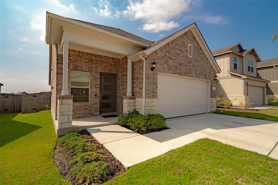 View of front of home with an attached garage, brick siding, concrete driveway, and stone siding View of front of home with an attached garage, brick siding, concrete driveway, and stone siding
