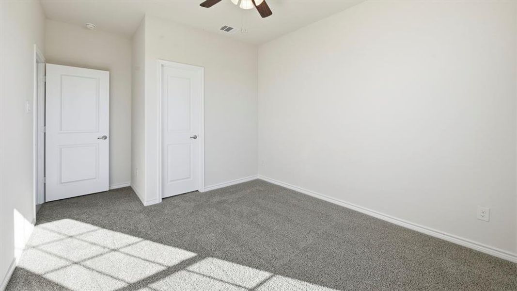 Unfurnished bedroom with carpet floors and a ceiling fan