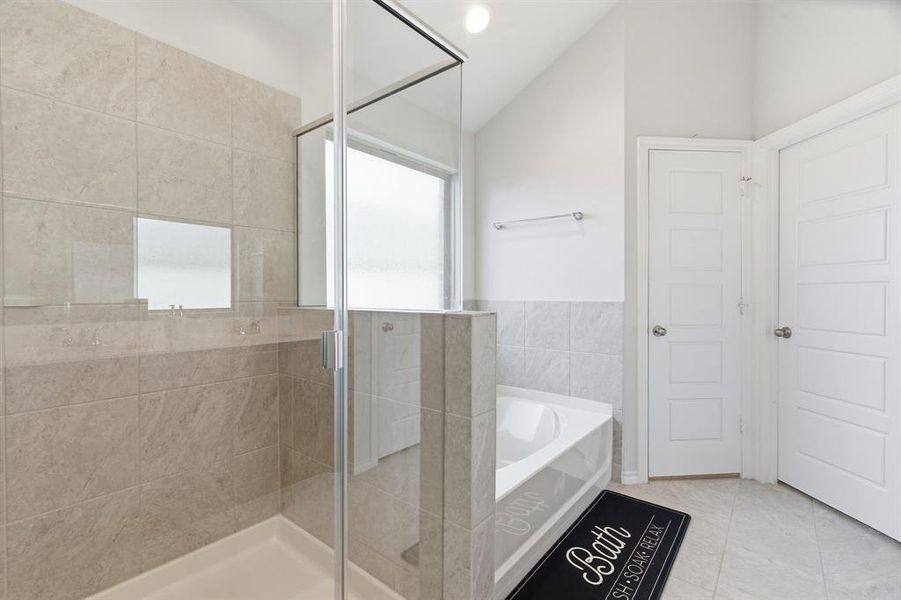 Bathroom featuring a stall shower, a bath, light tile patterned floors, vaulted ceiling, and recessed lighting