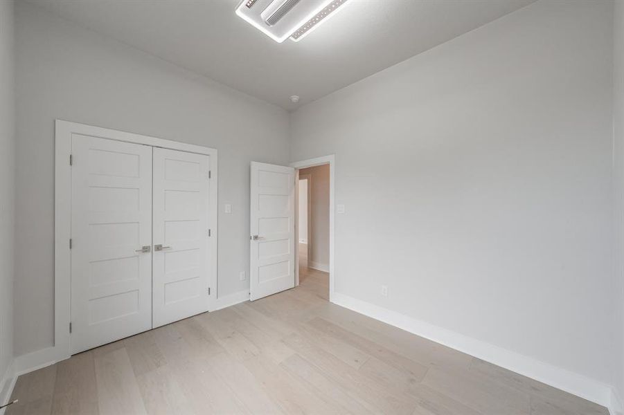 Unfurnished bedroom with cooling unit, light wood-style floors, and a closet