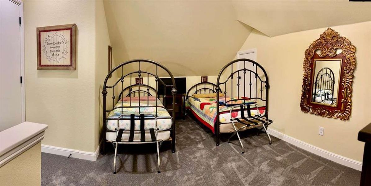 Bedroom featuring dark carpet and vaulted ceiling