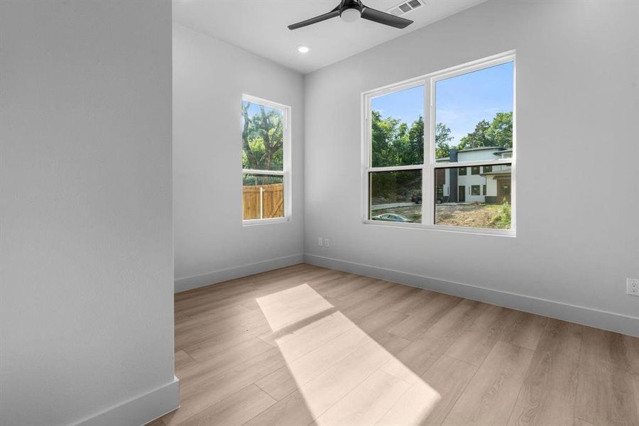 Empty room featuring light wood-style flooring, a ceiling fan, and recessed lighting