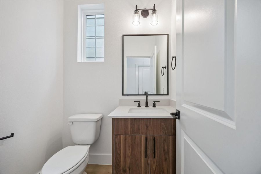 Stylish powder bath with floating-style vanity and framed mirror