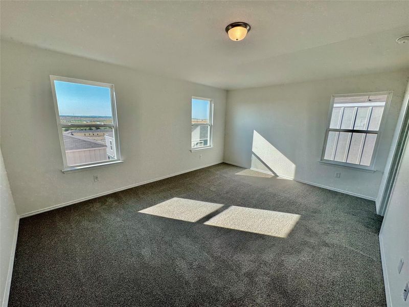 Unfurnished room with dark colored carpet and baseboards Unfurnished room with dark colored carpet and baseboards