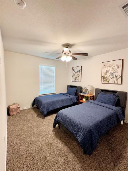 Carpeted bedroom featuring ceiling fan and baseboards Carpeted bedroom featuring ceiling fan and baseboards