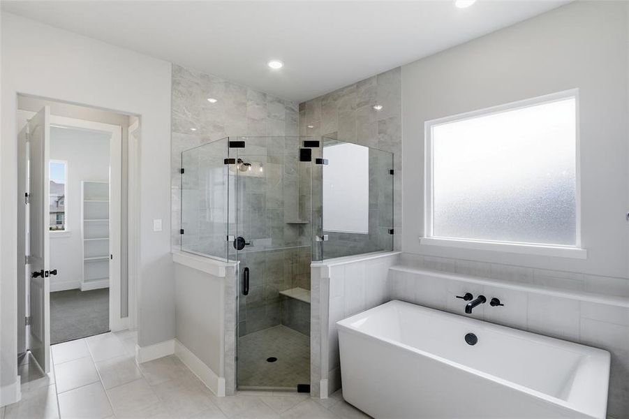 Full bath featuring a shower stall, a freestanding tub, tile patterned flooring, a walk in closet, and recessed lighting