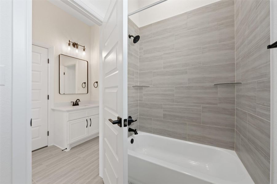 Full bathroom featuring tub / shower combination, vanity, and wood tiled floors Full bathroom featuring tub / shower combination, vanity, and wood tiled floors