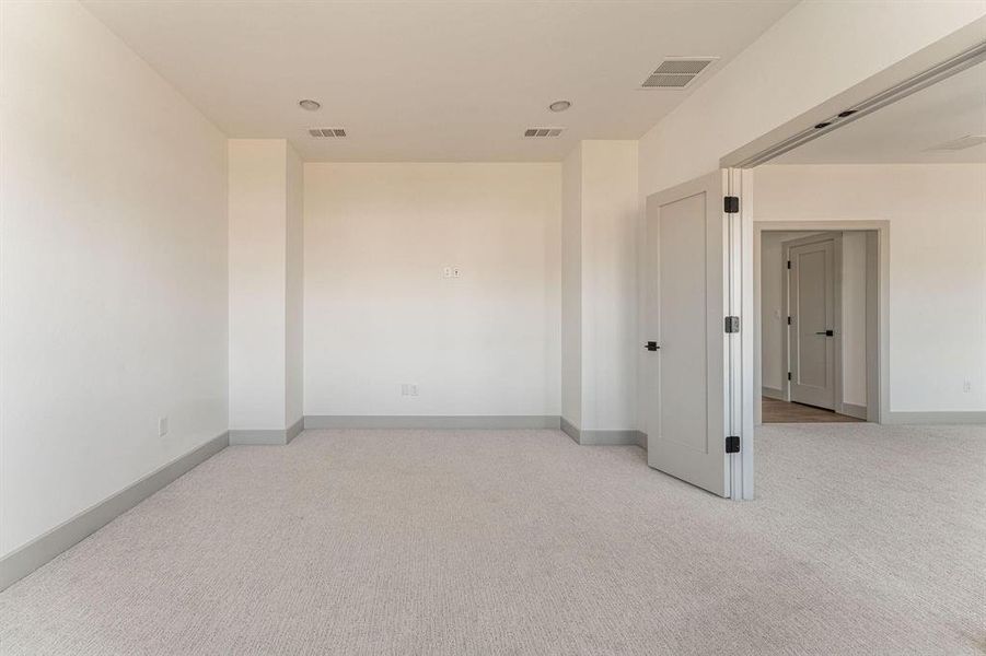 Spare room with light carpet and baseboards