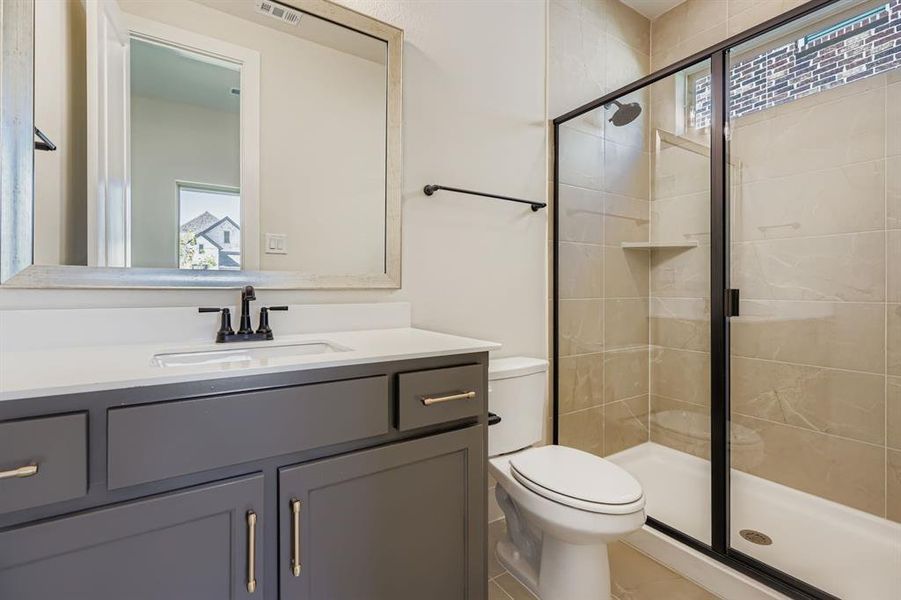 Full bathroom featuring plenty of natural light, a stall shower, and vanity