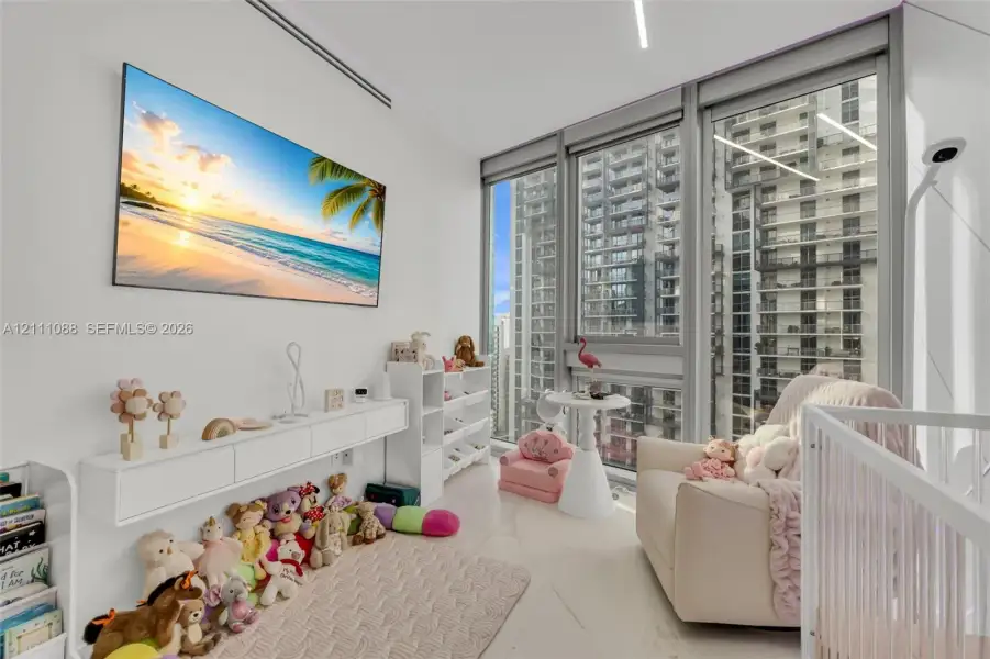 Floor-to-ceiling windows with expansive urban outlooks, light-toned stone-finish flooring, wall-mounted white cabinetry, and recessed linear LED lighting Floor-to-ceiling windows with expansive urban outlooks, light-toned stone-finish flooring, wall-mounted white cabinetry, and recessed linear LED lighting