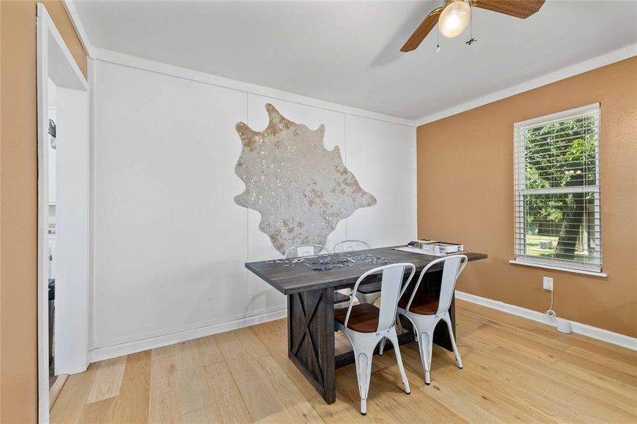 Dining room with a ceiling fan, wood finished floors, and ornamental molding Dining room with a ceiling fan, wood finished floors, and ornamental molding