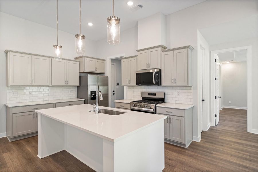 Kitchen featuring a central island with an integrated stainless steel sink and gooseneck faucet Kitchen featuring a central island with an integrated stainless steel sink and gooseneck faucet
