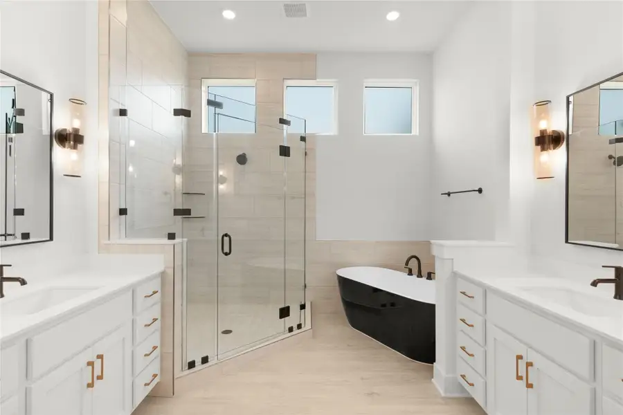 Full bathroom featuring two vanities, healthy amount of natural light, a stall shower, recessed lighting, and tile walls Full bathroom featuring two vanities, healthy amount of natural light, a stall shower, recessed lighting, and tile walls