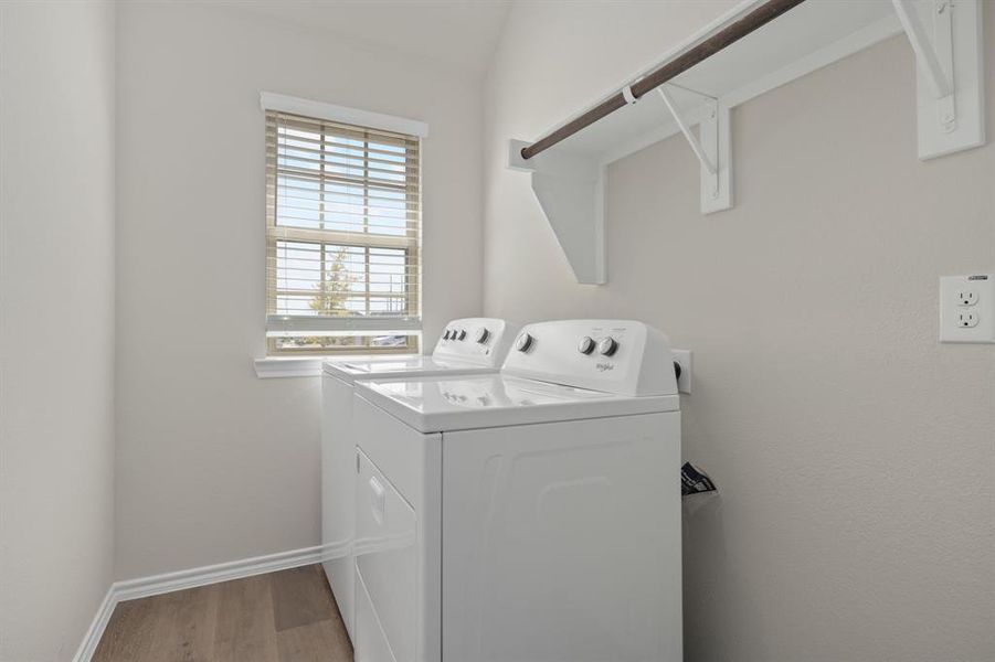 Washroom with light wood-style floors and washer and dryer Washroom with light wood-style floors and washer and dryer