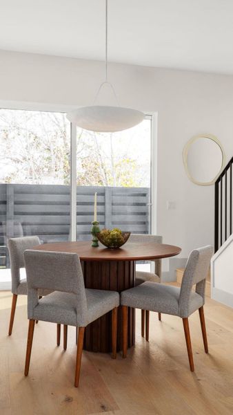 Dining room with plenty of natural light, light wood finished floors, and stairs