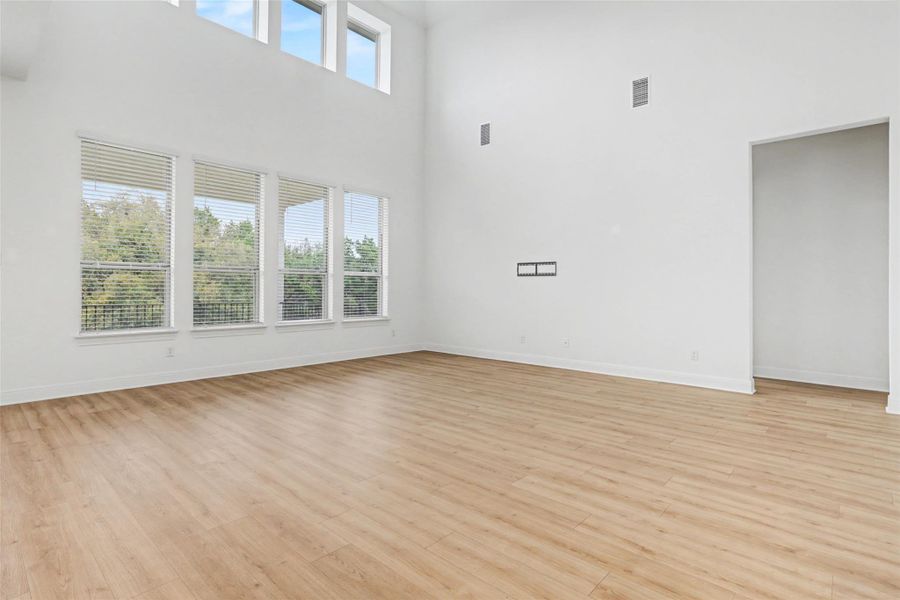 Empty room featuring a high ceiling and light wood finished floors