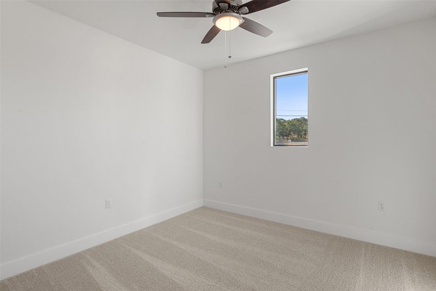 Empty room with carpet and a ceiling fan