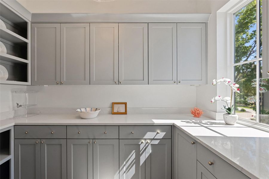 Bright, white countertops and ample cabinetry create a functional and well-lit workspace. Bright, white countertops and ample cabinetry create a functional and well-lit workspace.