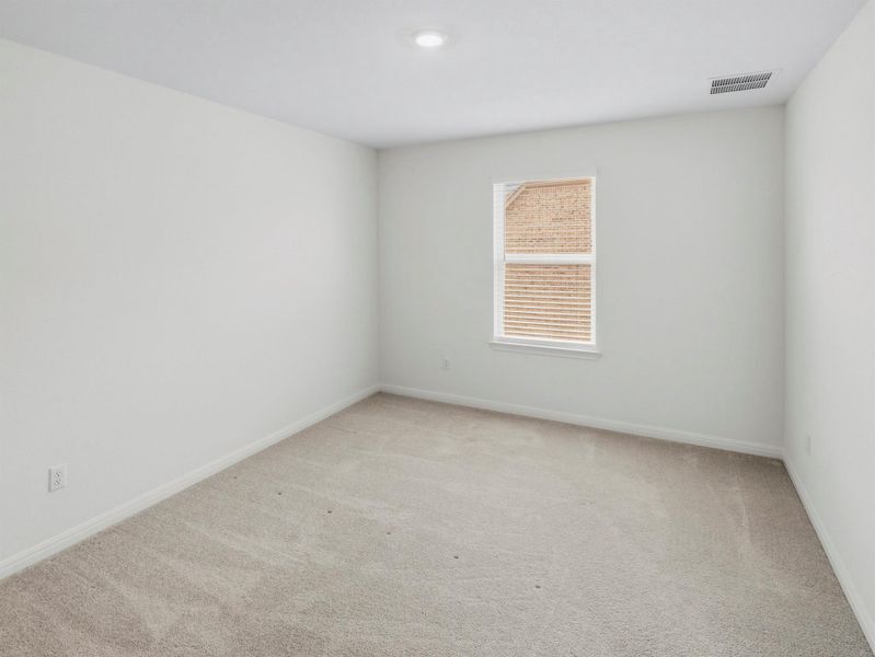 A well-lit bedroom awaits personalization with soft carpet and a bright window. A well-lit bedroom awaits personalization with soft carpet and a bright window.