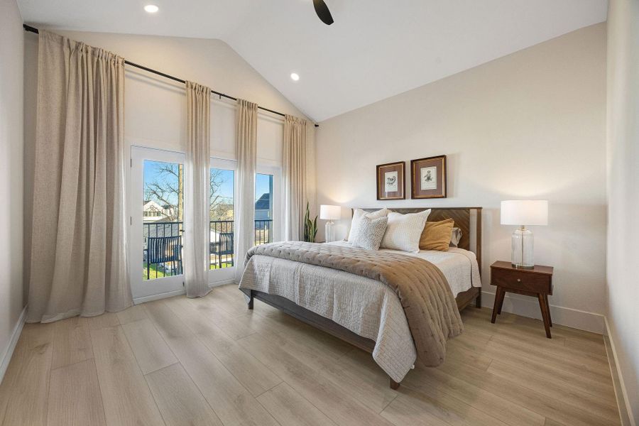 View of the primary bedroom with vaulted ceilings, double doors leading to a balcony. View of the primary bedroom with vaulted ceilings, double doors leading to a balcony.
