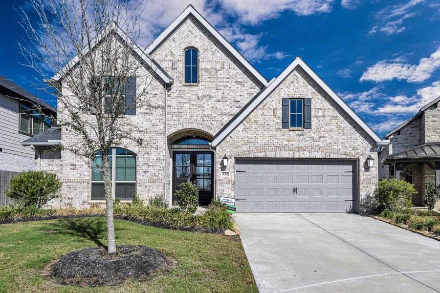Front exterior of a new home in Cross Creek West 55', Fulshear, TX, highlighting curb appeal (Image 2). Front exterior of a new home in Cross Creek West 55', Fulshear, TX, highlighting curb appeal (Image 2).
