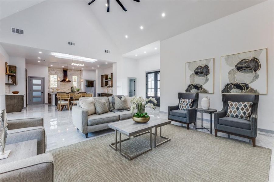 Living room featuring a notable chandelier and high vaulted ceiling