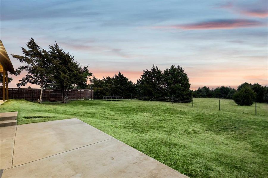 Yard at dusk featuring a patio area