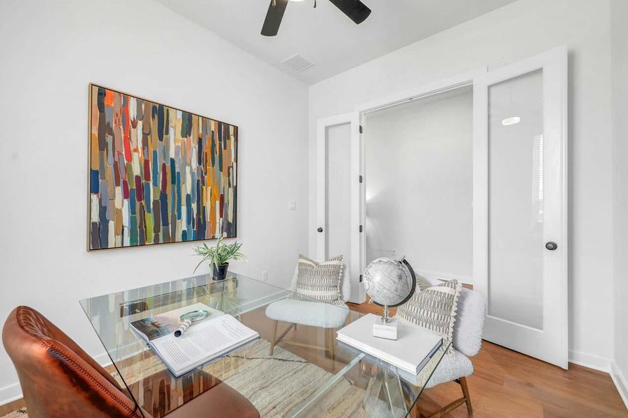 Sitting room featuring wood finished floors, visible vents, baseboards, and ceiling fan