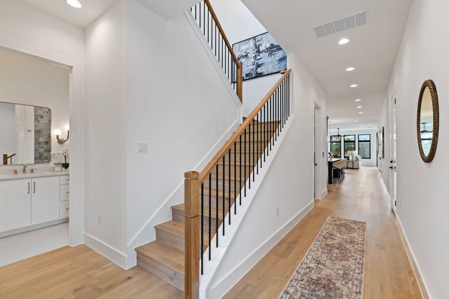 Stairs with wood finished floors, recessed lighting, and baseboards