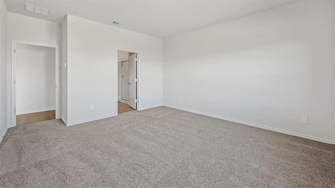 Spacious room featuring neutral carpeting, white walls, and white trim