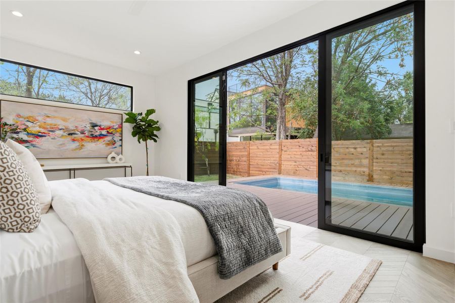 Spacious primary bedroom looks onto private pool