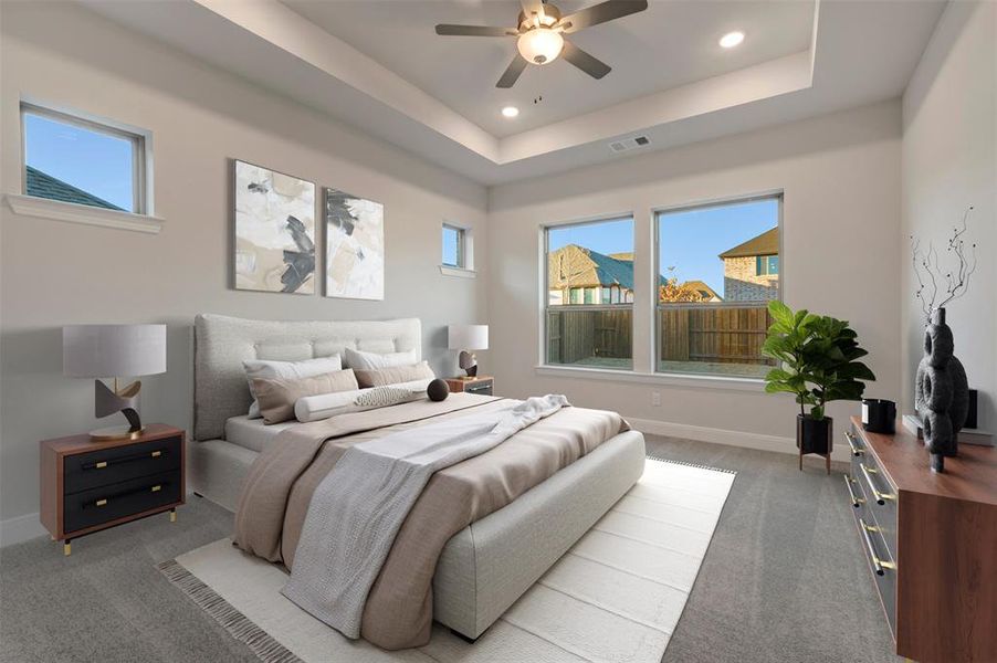 Carpeted bedroom featuring ceiling fan, recessed lighting, and a raised ceiling