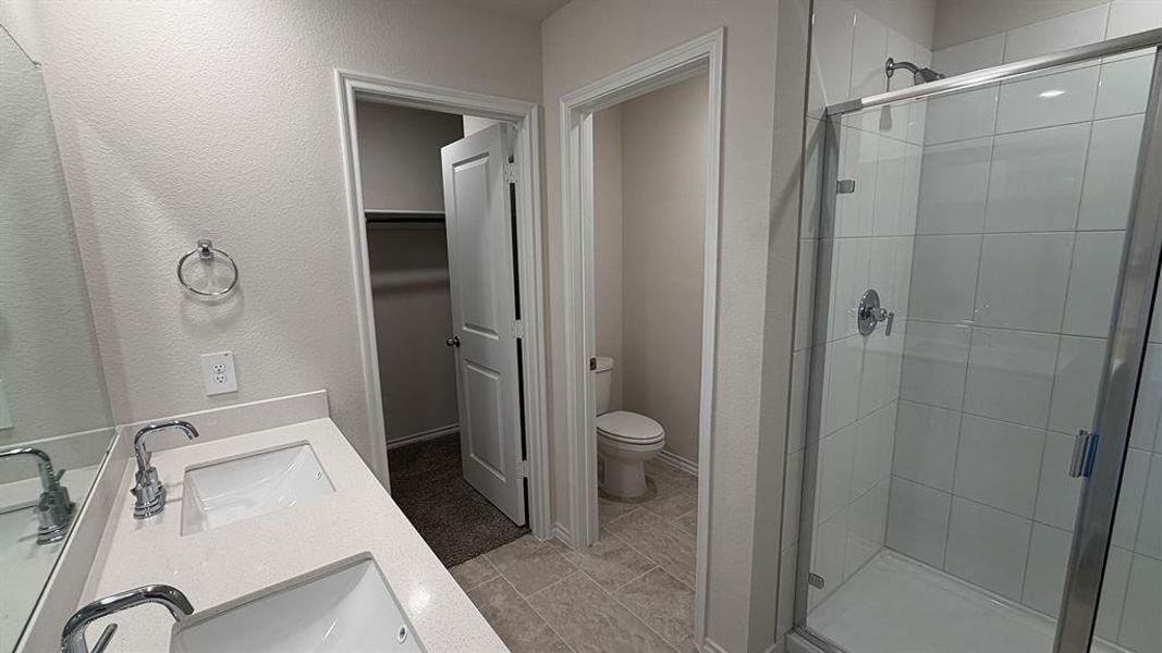 Dual vanity with undermount sinks and chrome fixtures, framed by a large wall mirror