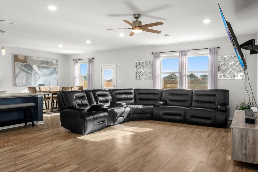 Living room featuring wood finished floors, plenty of natural light, ceiling fan, and recessed lighting