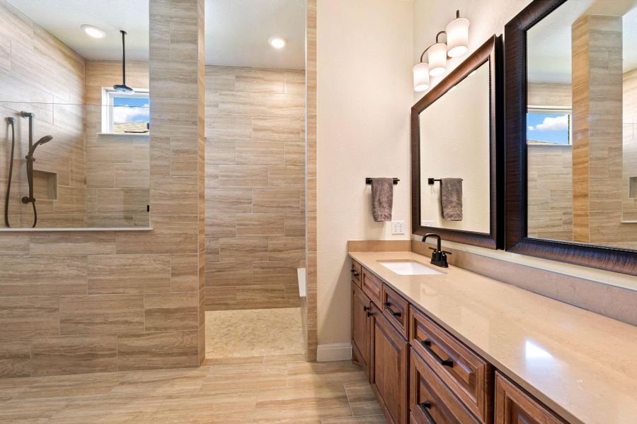 Well-lit master bathroom features a vanity with ample counter space, rich wooden cabinetry, and a spacious walk-in shower with tasteful tile work. Well-lit master bathroom features a vanity with ample counter space, rich wooden cabinetry, and a spacious walk-in shower with tasteful tile work.