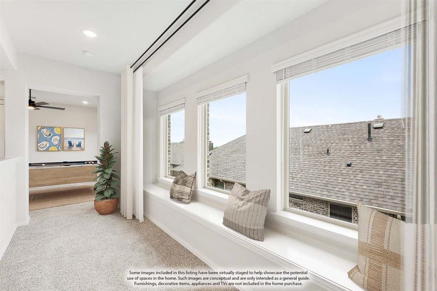 Bright sitting area with built-in window seat, large windows, and carpet flooring overlooking neighboring rooftops