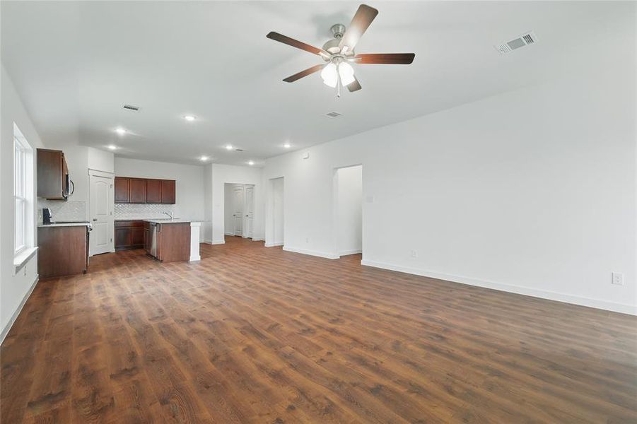 Unfurnished living room with dark wood-style floors, ceiling fan, and recessed lighting Unfurnished living room with dark wood-style floors, ceiling fan, and recessed lighting