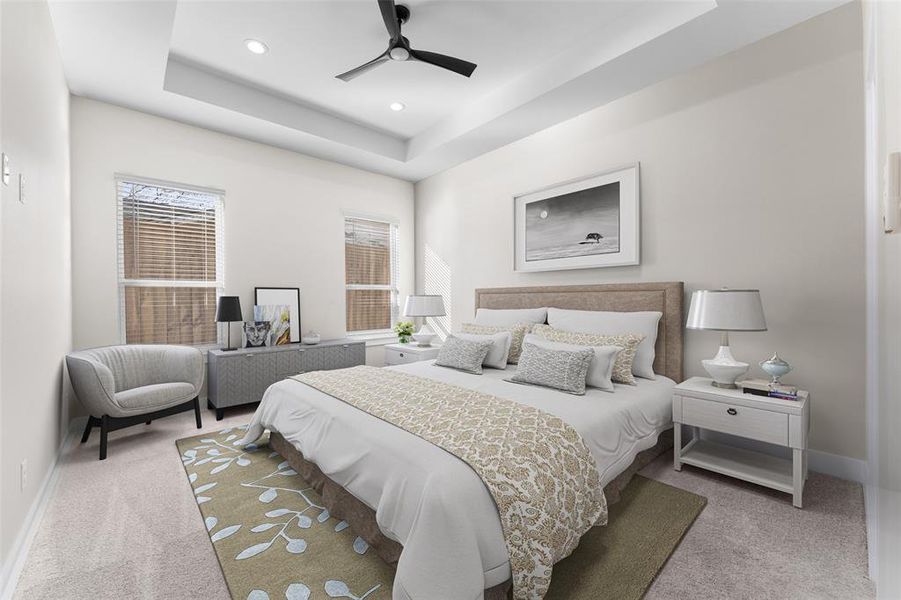 Bedroom with ceiling fan, a tray ceiling, and light carpet